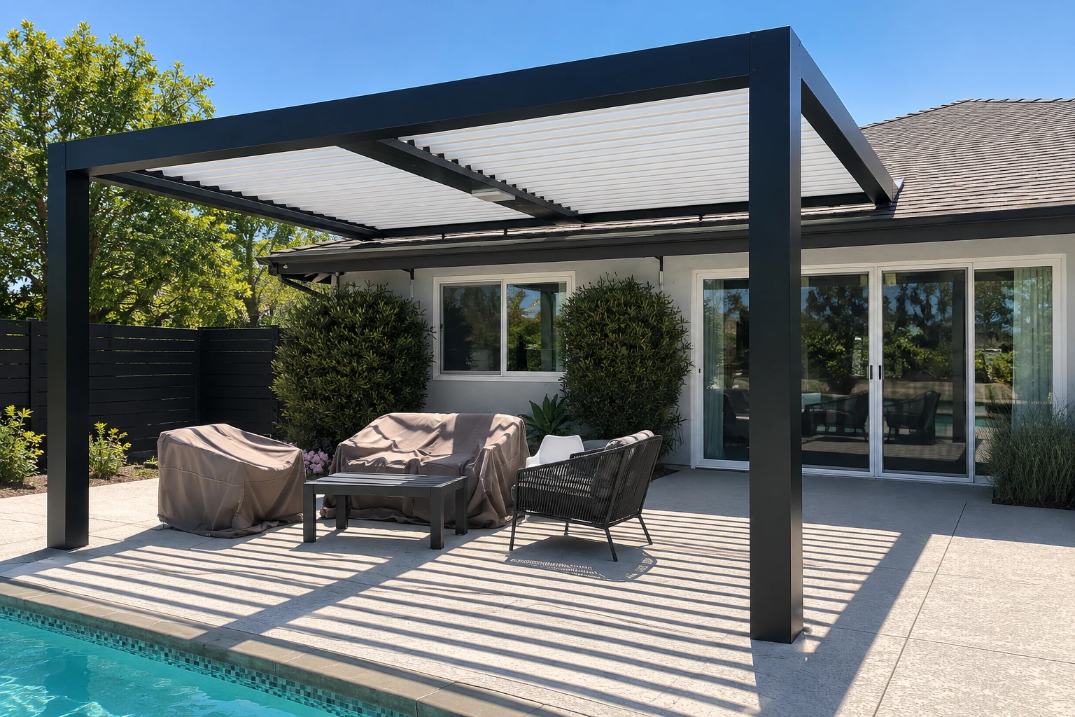 Black patio cover with a slatted white roof shading lounge furniture beside a swimming pool.